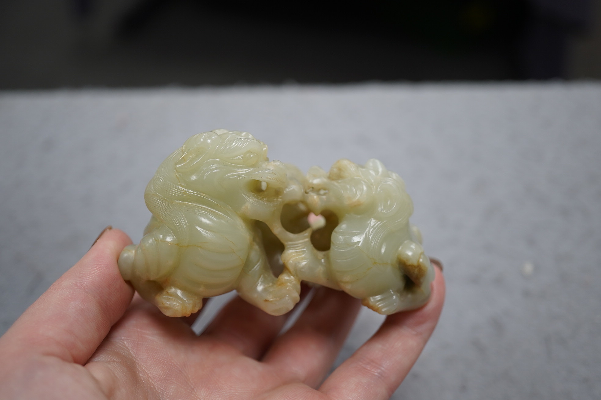 A Chinese celadon and russet jade group of two lion-dogs, 19th century